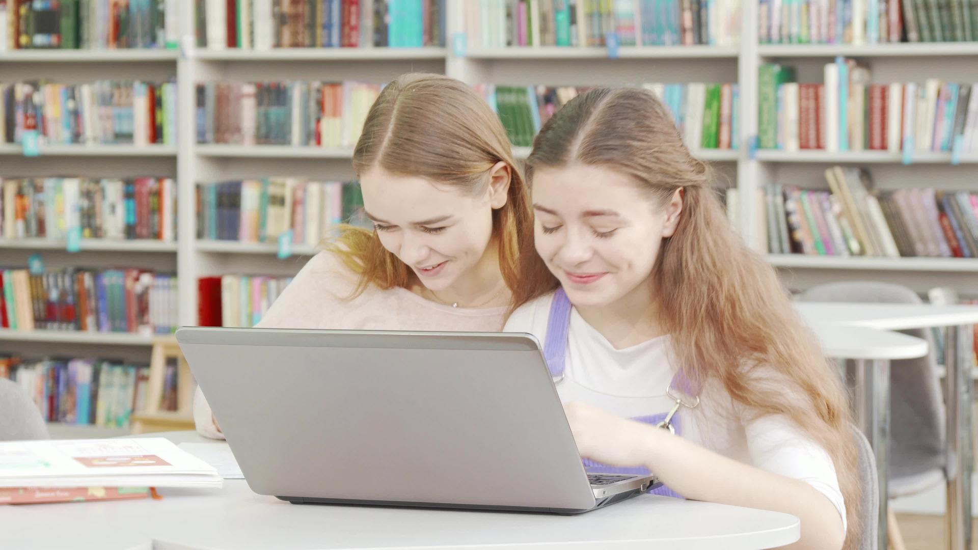 快乐的女孩在图书馆一起学习时会微笑视频的预览图