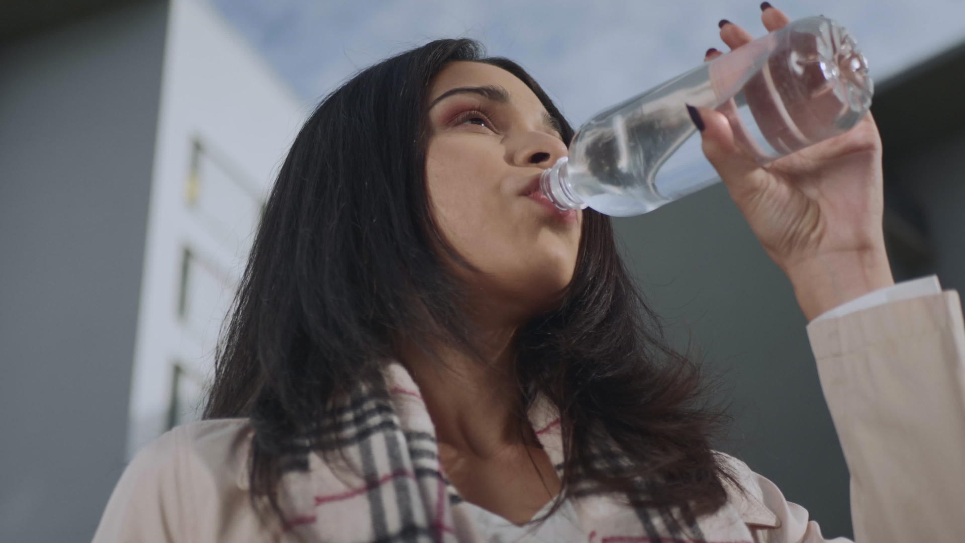 女商人在街上喝瓶装饮用水视频的预览图