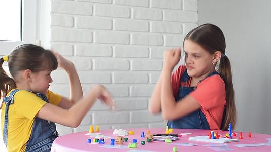 两个女孩玩桌子游戏和一个朋友玩电弧游戏视频的预览图