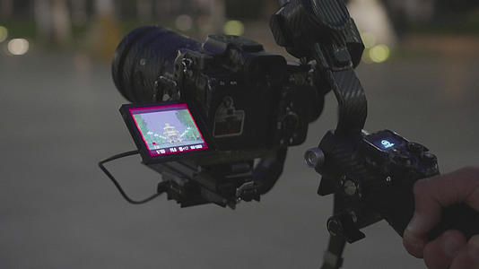 4k素材慢镜头升格拍摄城市夜晚手持稳定器摄像的人视频的预览图