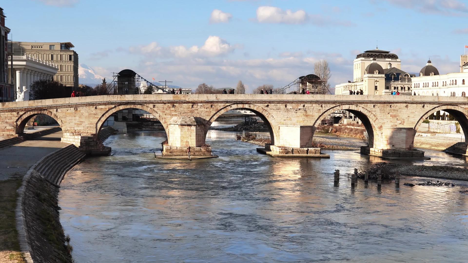 古老的石桥位于马塞多尼亚斯科佩耶的瓦尔达尔河上视频的预览图