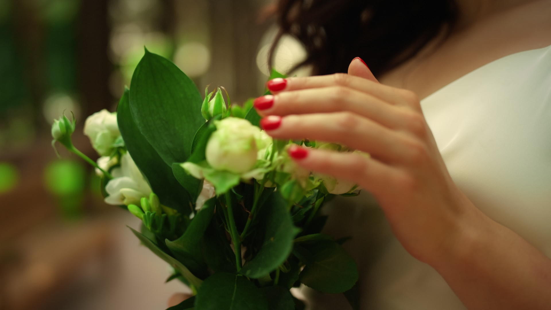 女人用手触摸公园的花束站在中用鲜新娘视频的预览图