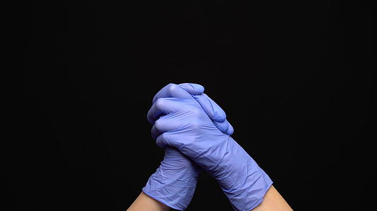 戴着乳胶医疗手套的女性在黑色背景上鼓掌视频的预览图