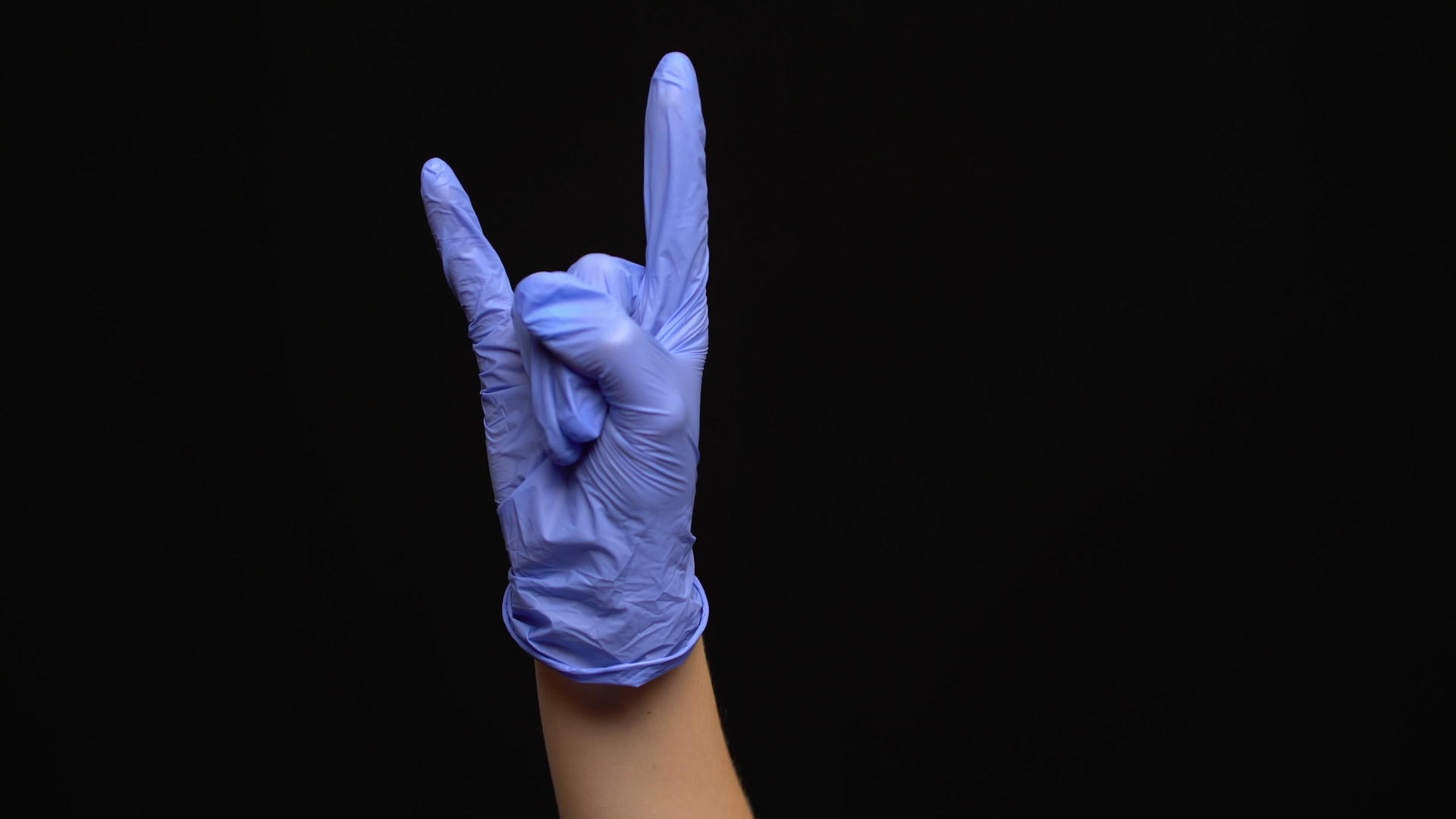 女性用乳胶手戴的医用手套将岩石手势与黑色背景隔离视频的预览图