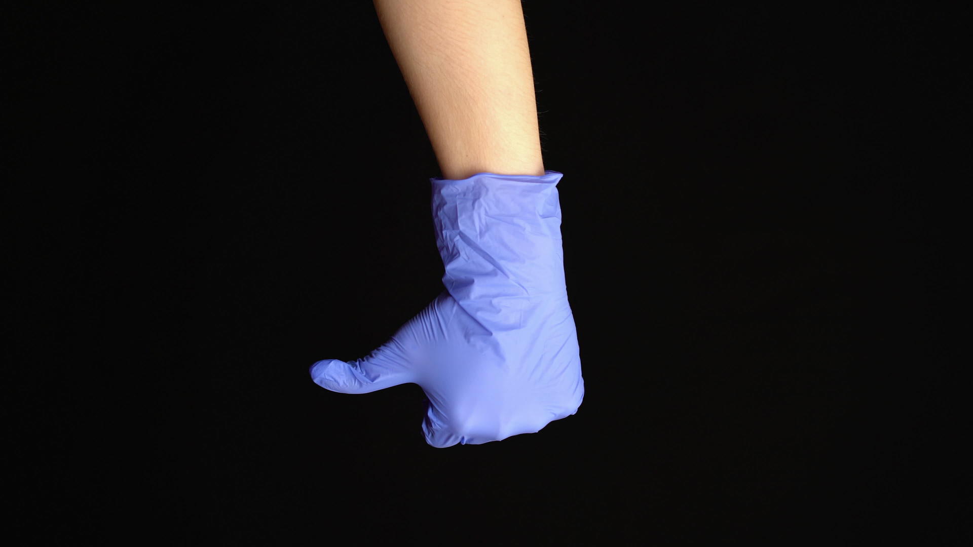 女性在黑色背景下戴着乳胶医疗手套视频的预览图