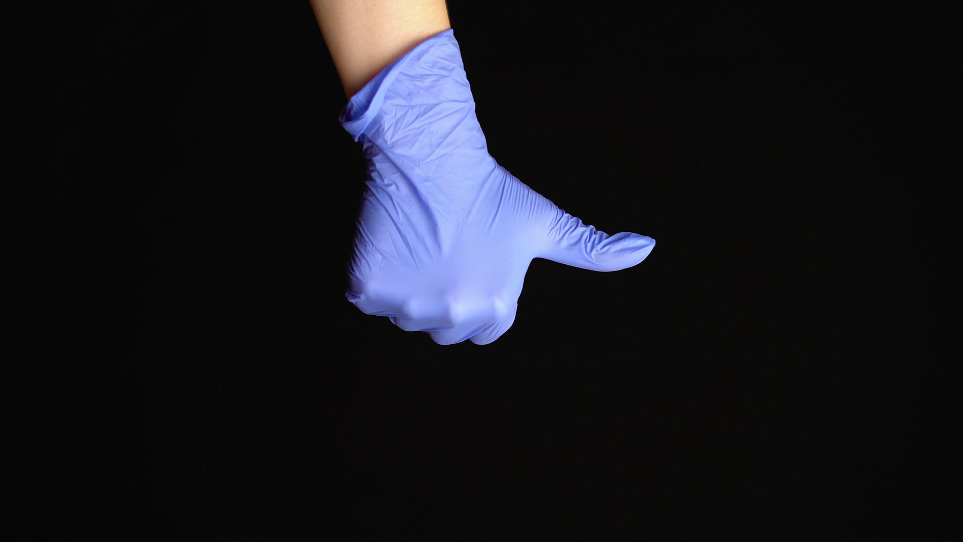 女人把手放在乳胶医疗手套上就像被放在黑色背景下视频的预览图
