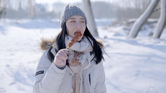 4K女孩冬天雪景品尝吃冰糖葫芦视频的预览图