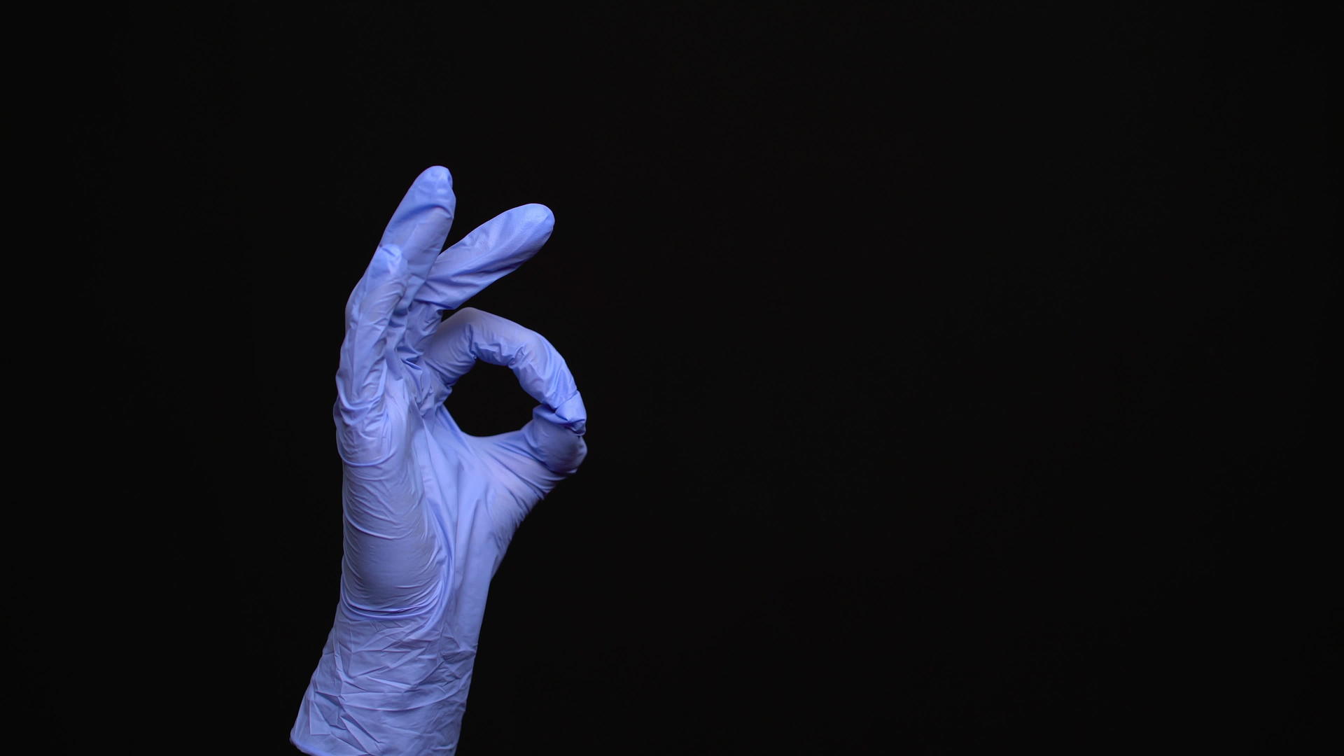 女性可以用乳胶手戴医用手套在黑色背景上做好手势视频的预览图