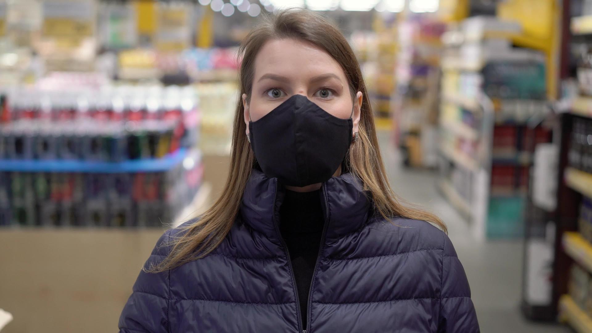 妇女在超市商店的车厢里戴着面罩和保护面罩可口可口的科罗纳尔视频的预览图