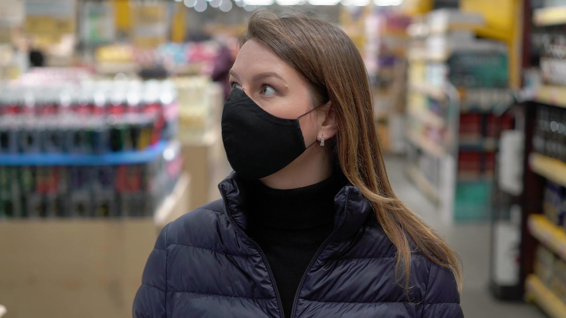 妇女在超市商店的车厢里戴着面罩和保护面罩可口可口的科罗纳尔视频的预览图