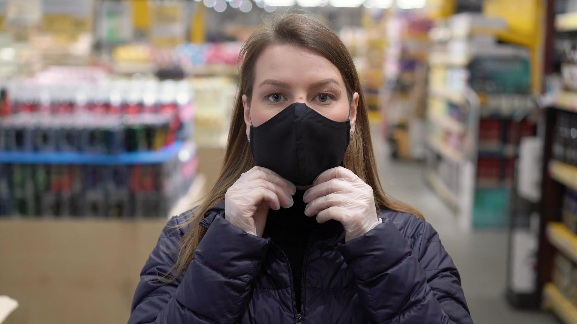 在超市商店的车厢里妇女戴着保护面罩视频的预览图