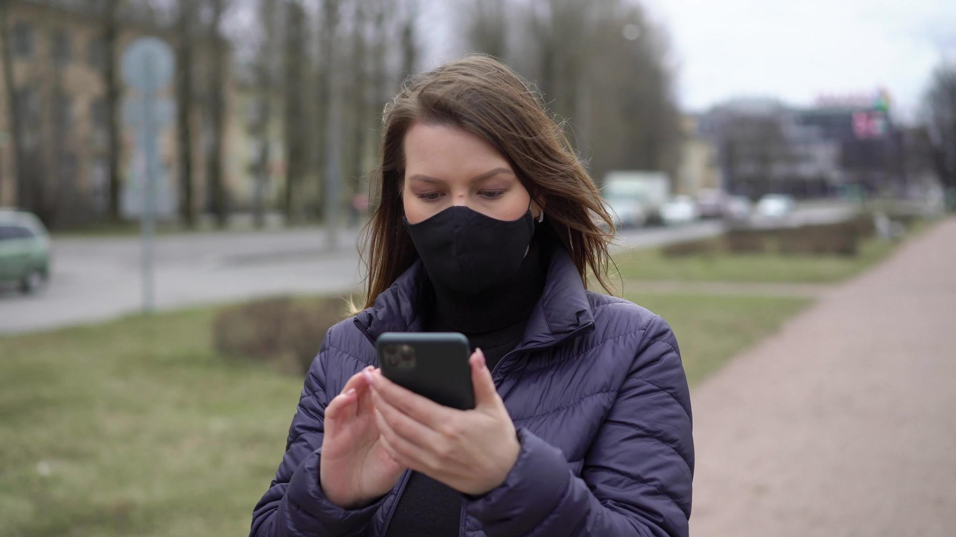 在有手机的城市妇女戴着保护性口罩视频的预览图