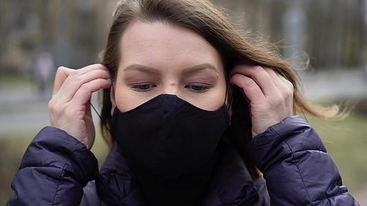 在城市里妇女戴上保护口罩视频的预览图