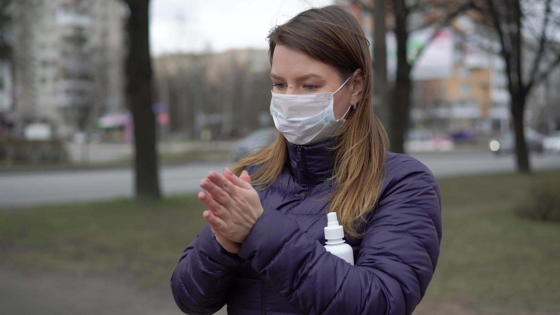 在一个城市里妇女面对着保护性口罩手洗洁净剂视频的预览图
