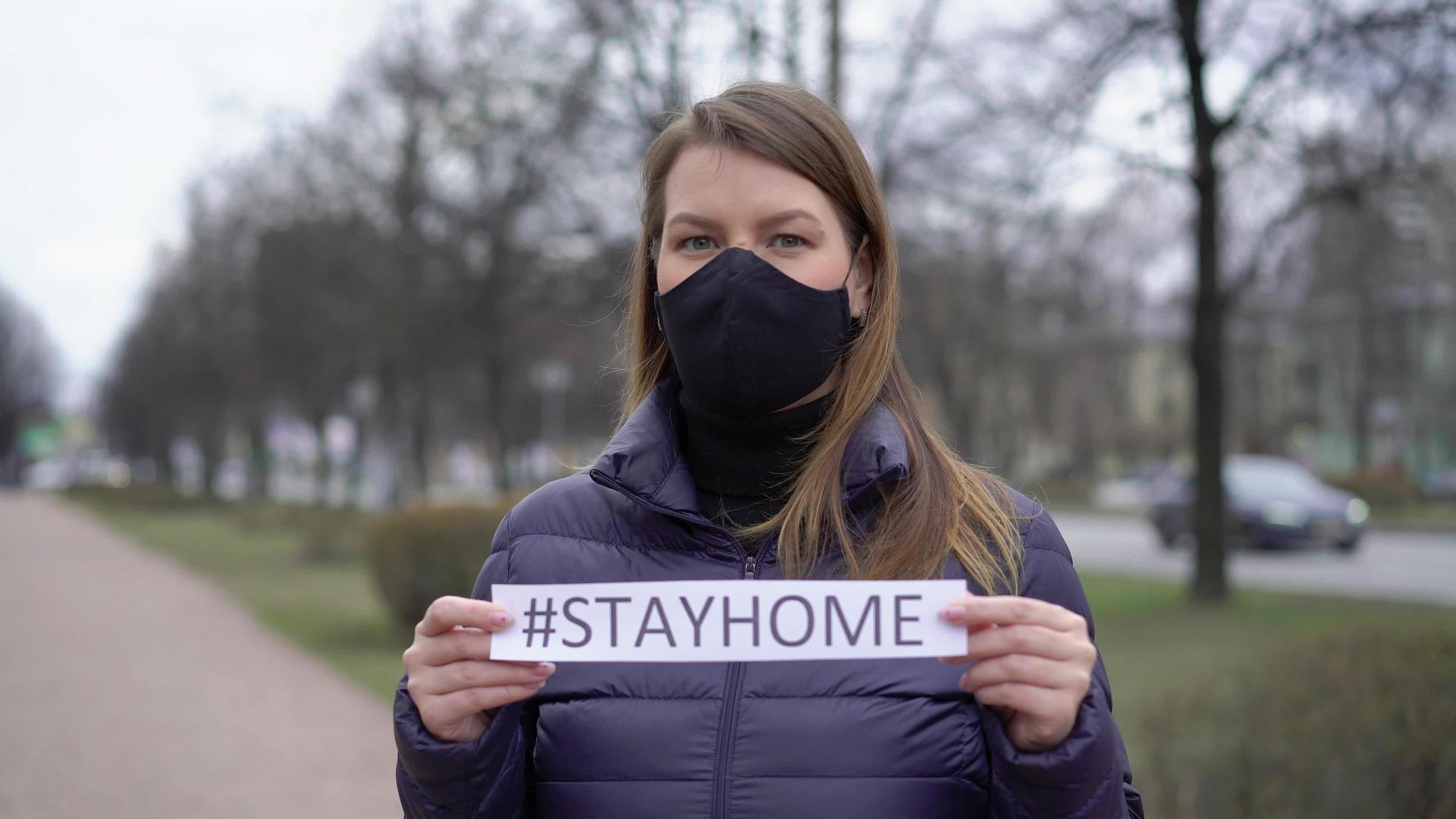 在一个城市面对保护面具的妇女呆在家里视频的预览图