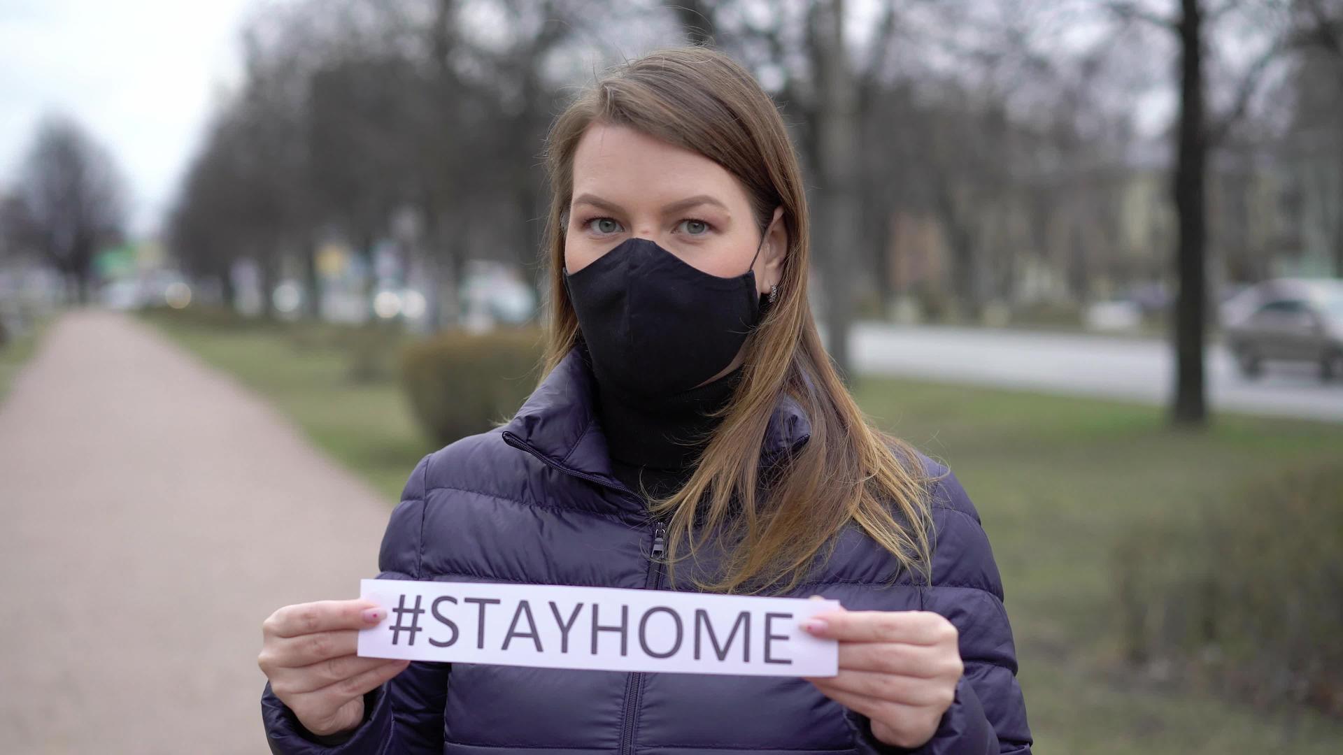 在一个城市面对保护面具的妇女呆在家里视频的预览图