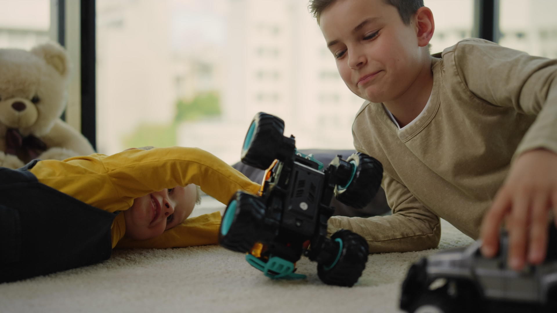 哥哥和哥哥在地毯上玩玩具车的孩子们很开心视频的预览图