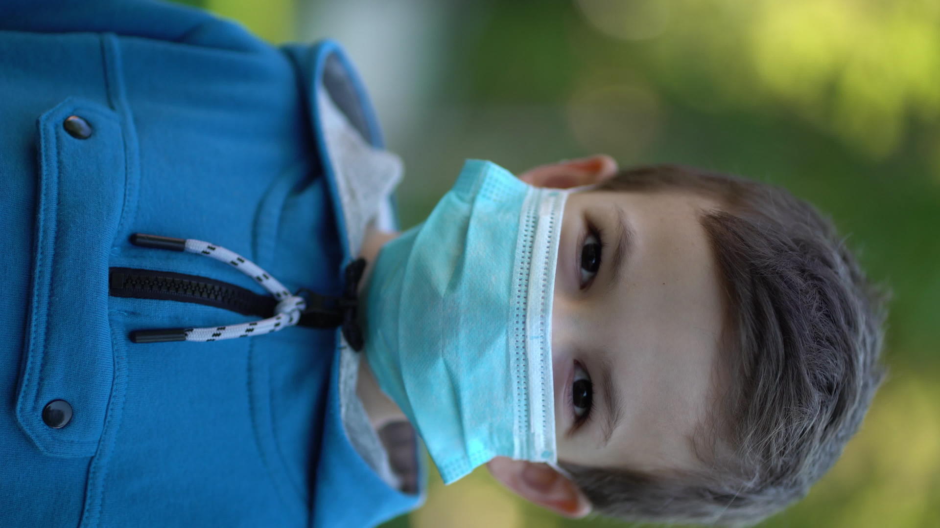 垂直视频病小男孩外出时用医用口罩遮住肖像的外观视频的预览图