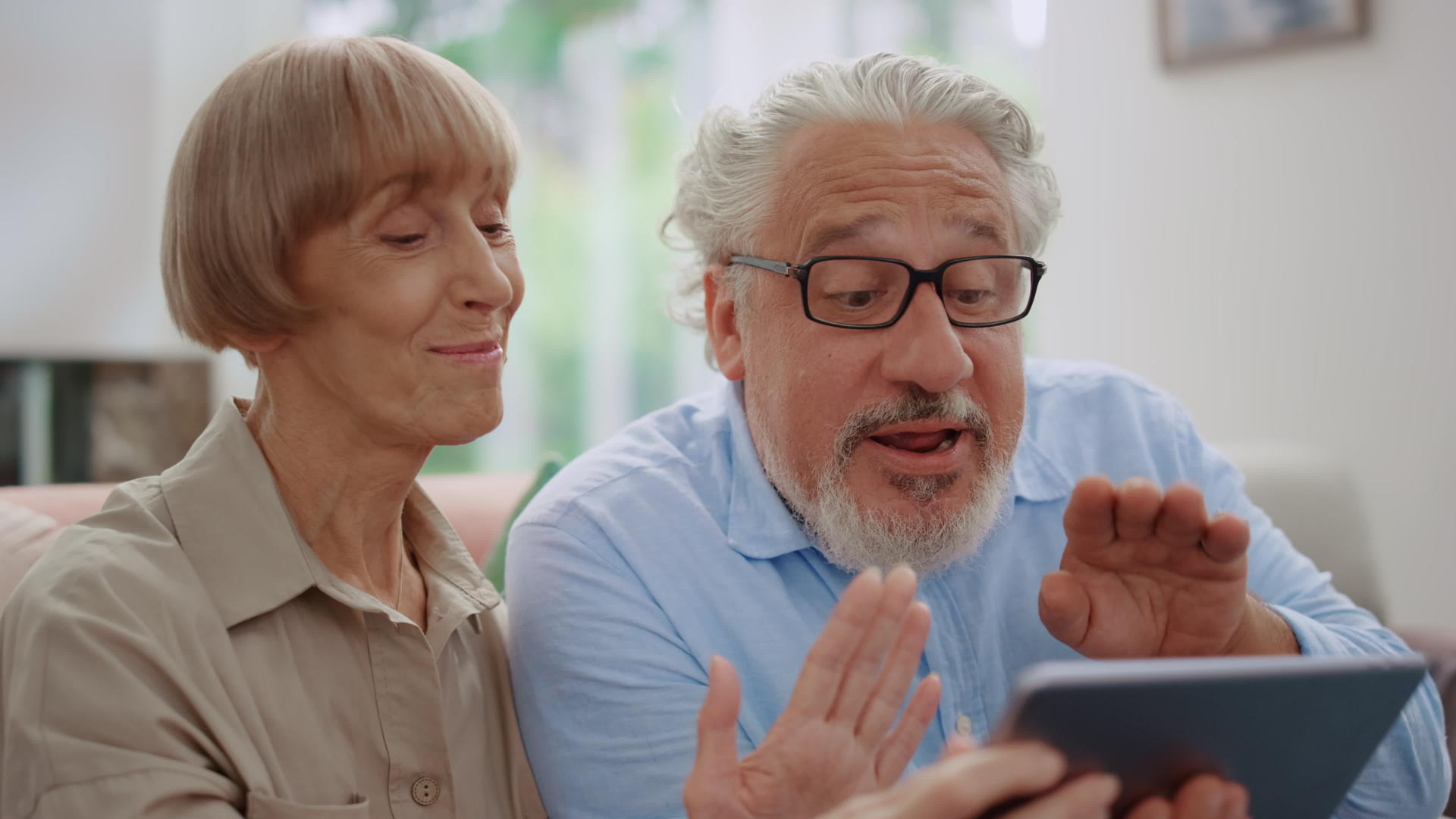 快乐的老年男女在视频通话中用相机挥手视频的预览图