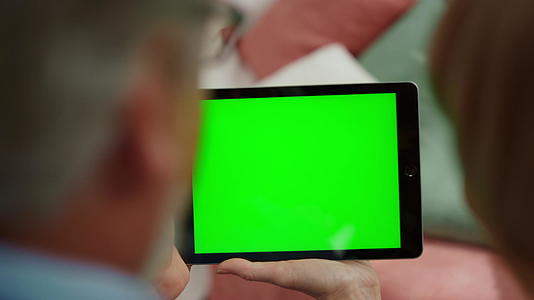 【不需要肖像权】成熟男女使用绿屏平板电脑视频的预览图