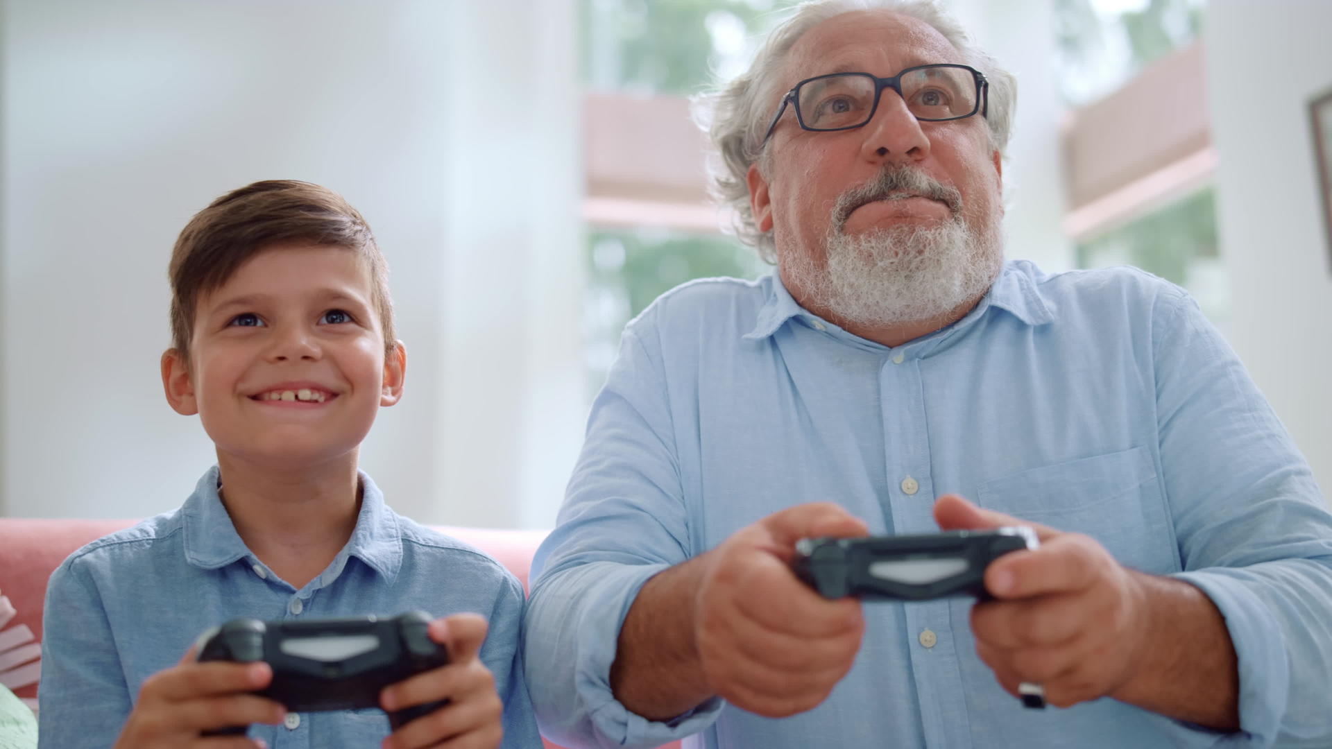 祖父和孙子一起玩电子游戏视频的预览图