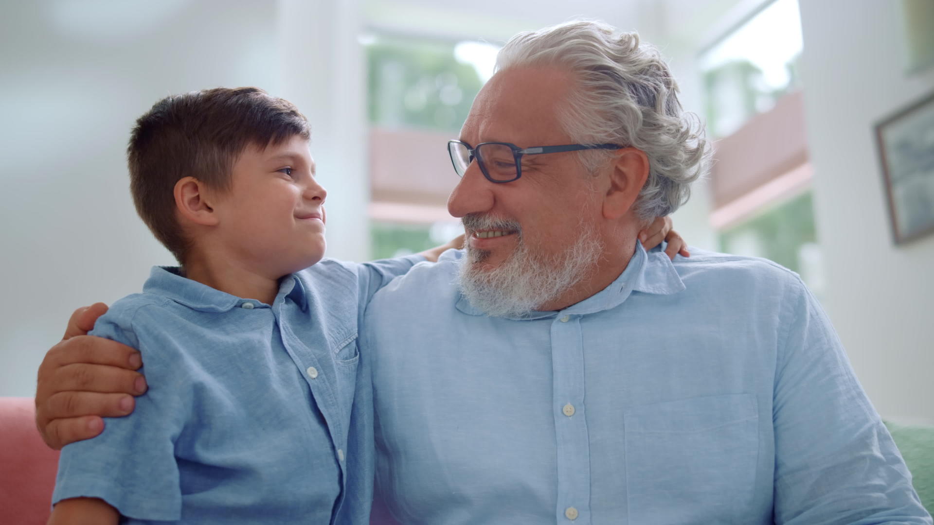 快乐的祖父和孙子在客厅里拥抱在一起视频的预览图