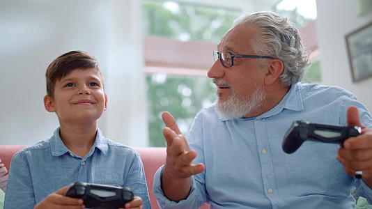老人和孙子在家玩游戏机视频的预览图