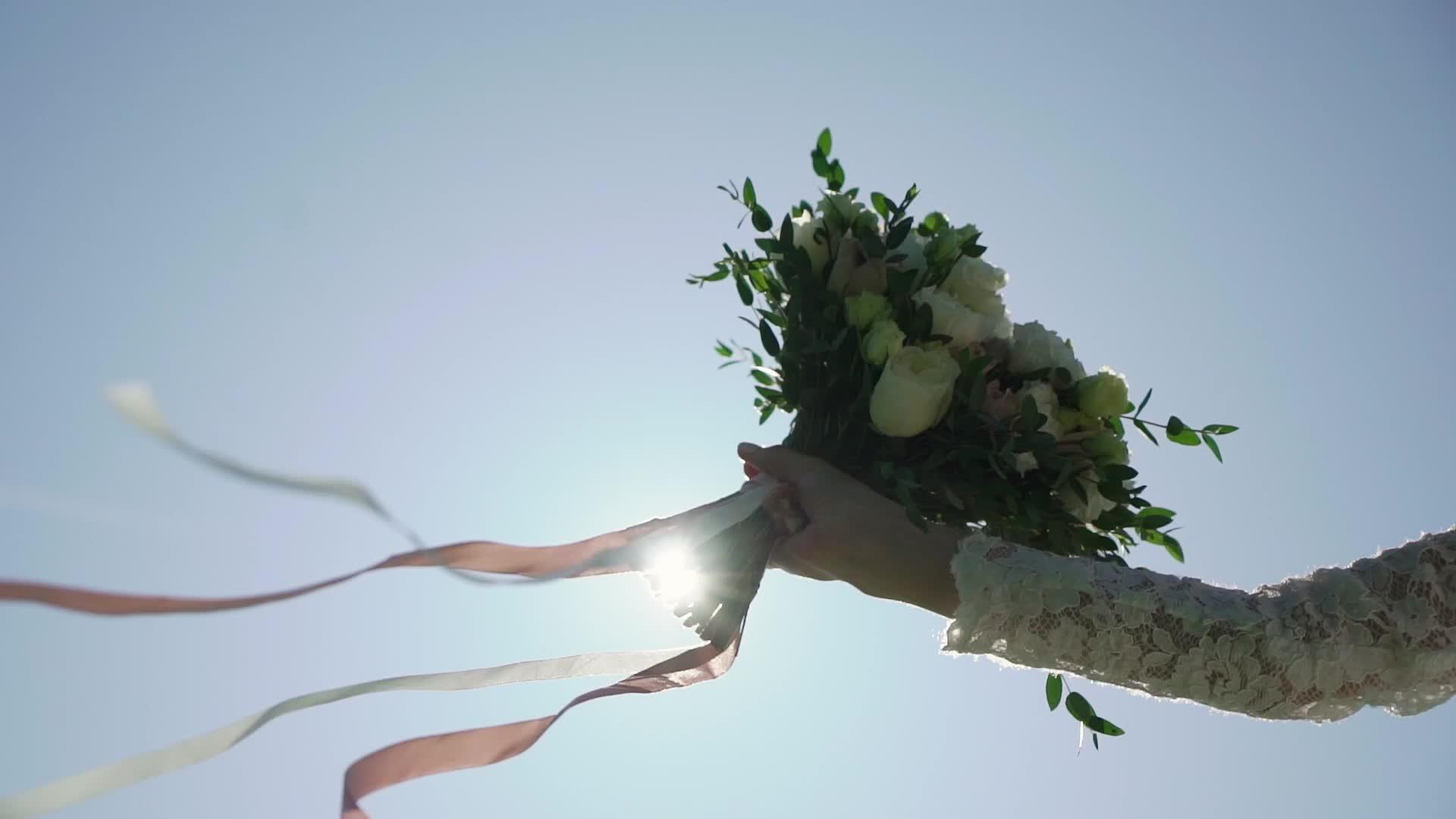 公园里穿着结婚礼服的年轻新娘拿着花束和白色豪华礼服视频的预览图