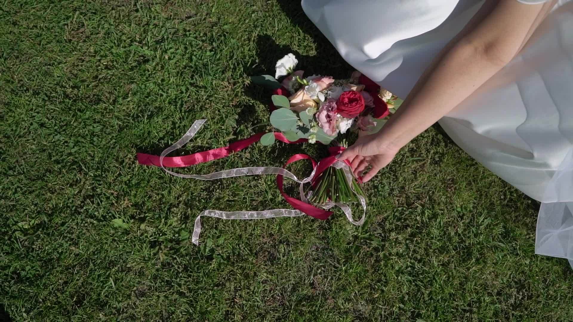 公园里穿着结婚礼服的年轻新娘拿着花束和白色豪华礼服视频的预览图