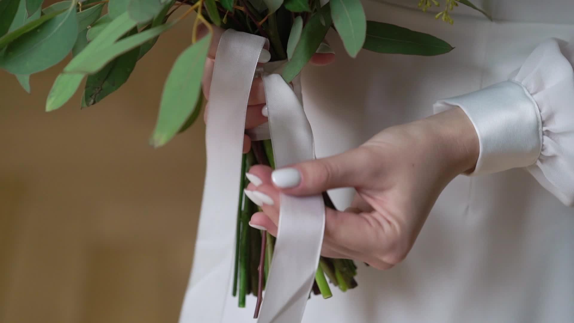 穿着结婚礼服的年轻新娘在室内盛开花束和白色豪华礼服视频的预览图