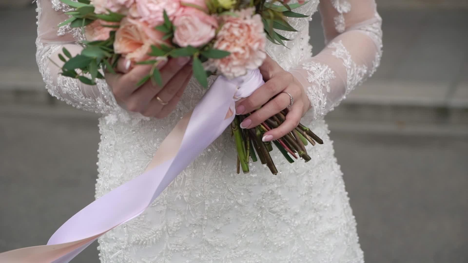 穿着结婚礼服的年轻新娘在城市里穿着花束和白色豪华礼服视频的预览图