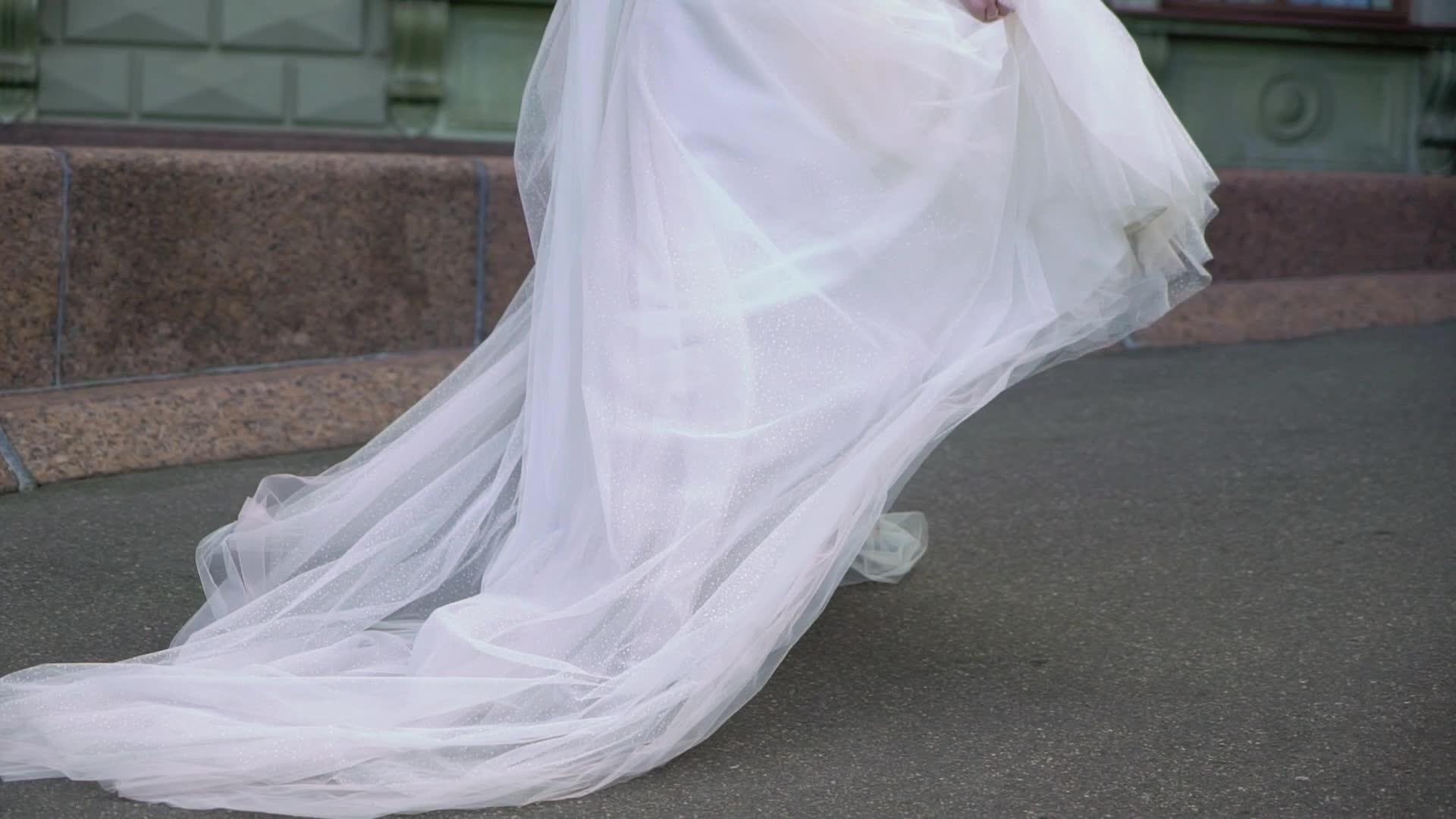 穿着结婚礼服的年轻新娘在城市里穿着白色豪华礼服视频的预览图