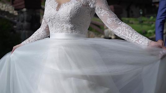 穿着婚纱的年轻新娘在公园里穿着白色豪华服装视频的预览图