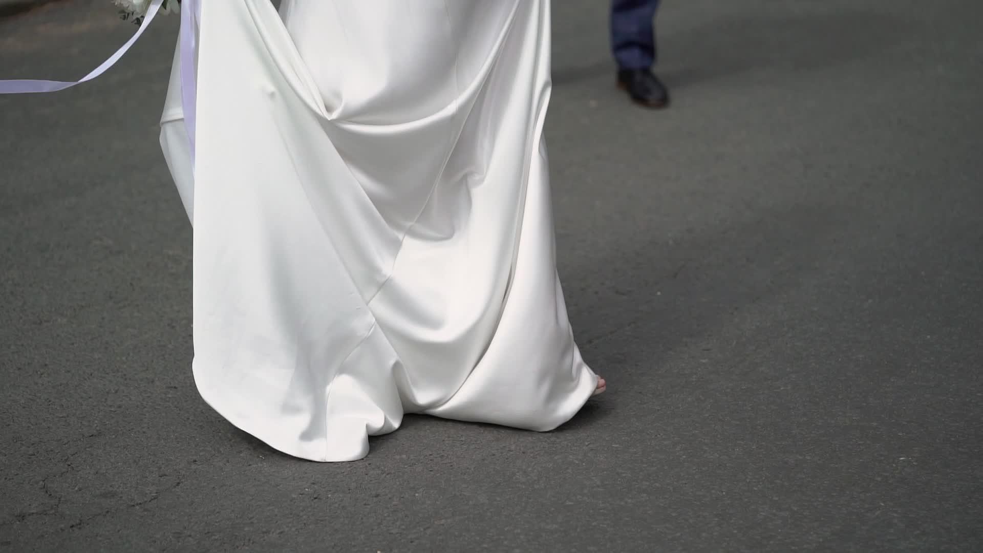 穿着婚纱的年轻新娘在城市里穿着白色豪华服装视频的预览图