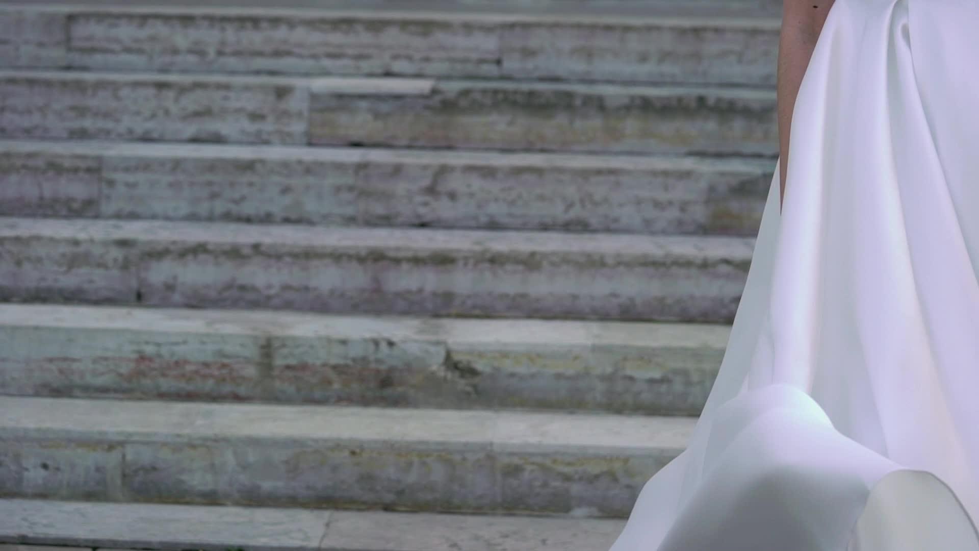 穿着婚纱的年轻新娘在城市里挥舞着尾巴扔着白色豪华礼服视频的预览图
