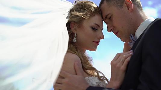 年轻美女新娘穿着婚纱拥抱亲吻新郎视频的预览图
