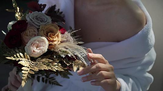 穿着内衣或浴袍的年轻美女新娘花束婚礼早上女人摆姿势视频的预览图