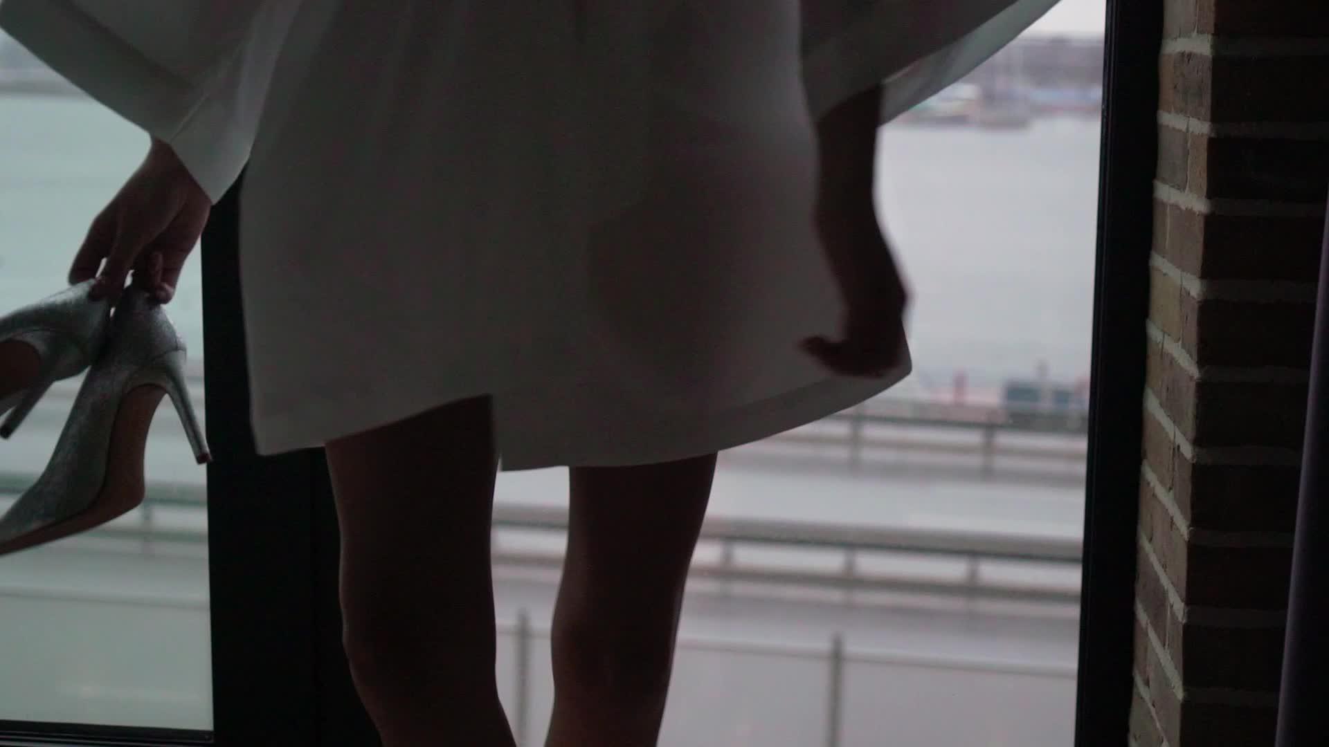穿着丝绸浴袍的年轻女子穿着鞋子到窗前兜风视频的预览图