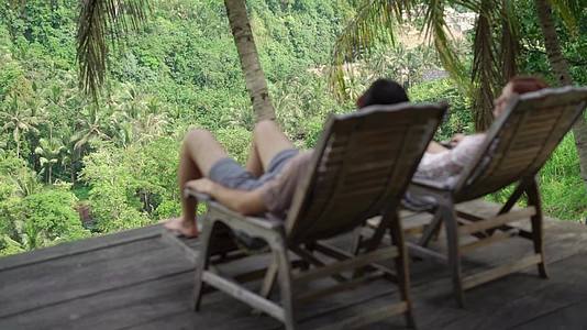 男人和女人坐在丛林的阳台上视频的预览图