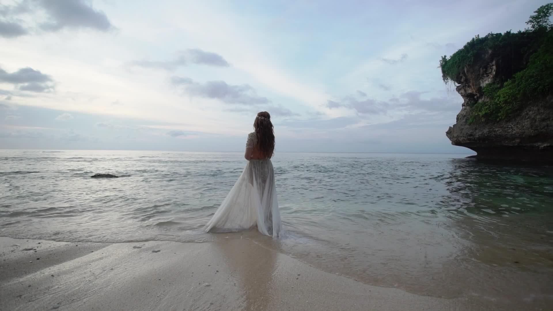 晚上年轻的新娘或日落在海边的海滩上视频的预览图