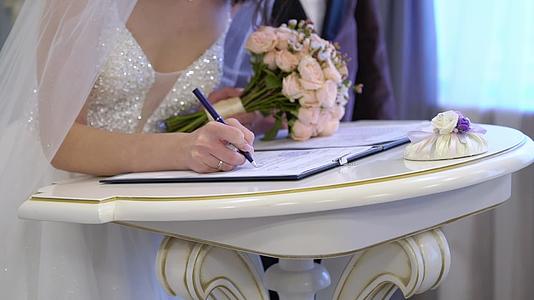 新娘和新郎在婚礼上签署了文件女孩拿着一束花视频的预览图