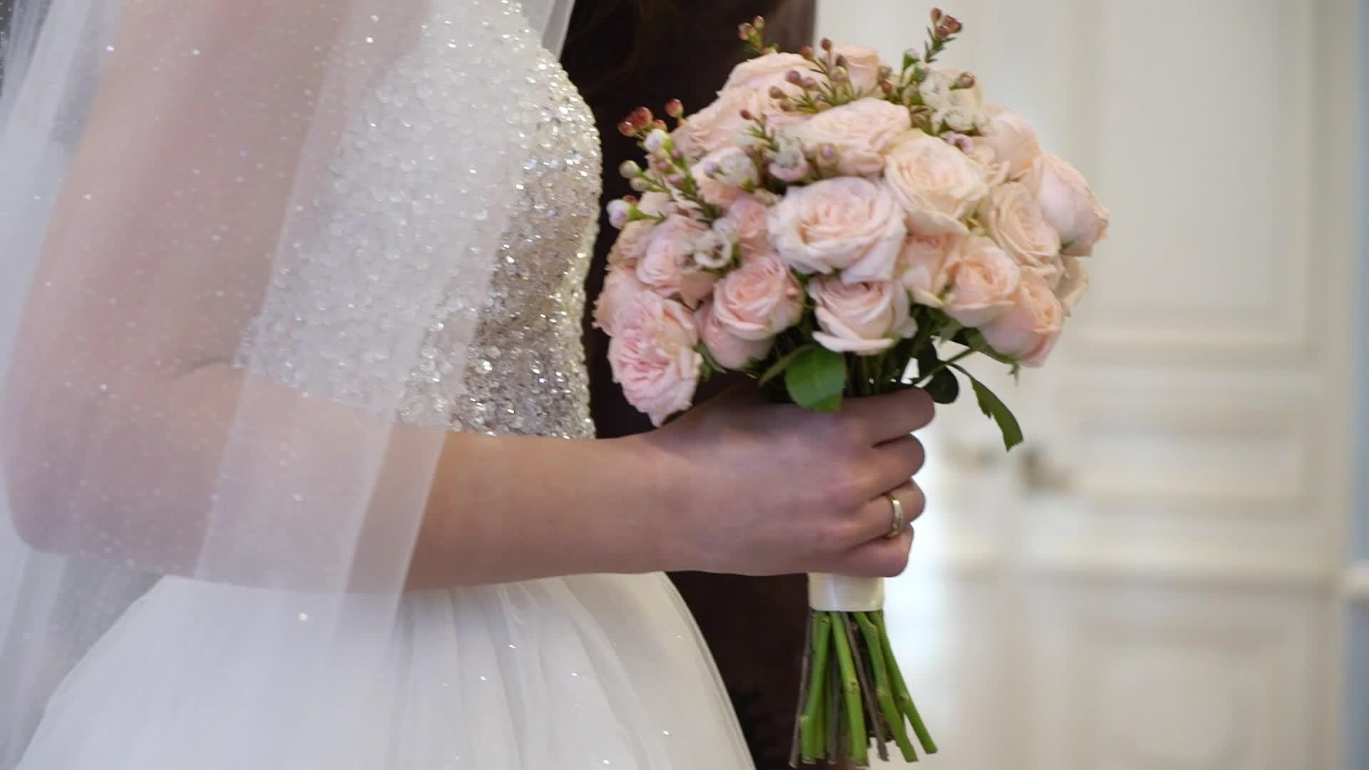 新娘和新郎把女孩留在婚礼上手里拿着花束视频的预览图