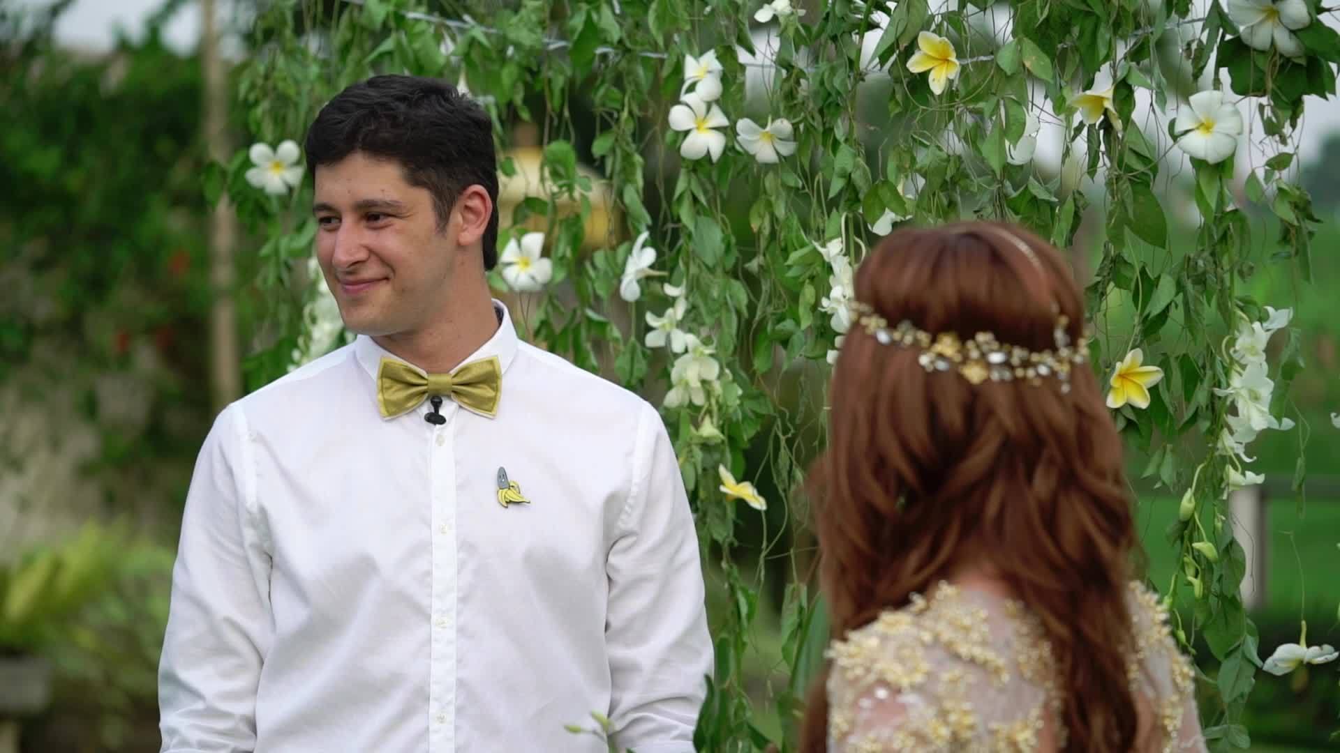 婚礼上新婚夫妇和新郎在热带花园里可爱的新婚夫妇视频的预览图