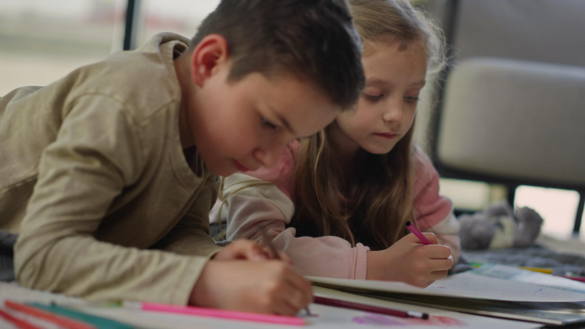 男孩和女孩在地板上画彩色图片可爱的兄弟姐妹在书店画画视频的预览图