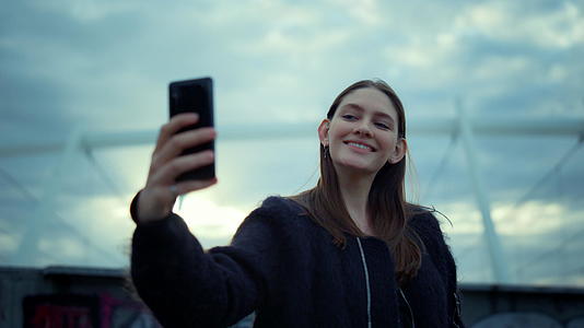 在现代城市的智能手机上自拍的女孩快乐女性使用手机Name视频的预览图