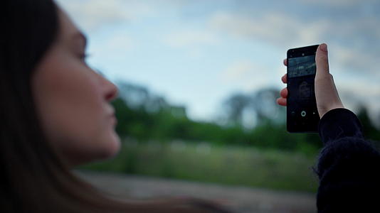 女孩用手机拍照女性在智能手机相上摆姿势视频的预览图