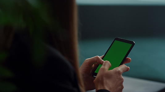 在手机上用绿屏打字的女商人视频的预览图