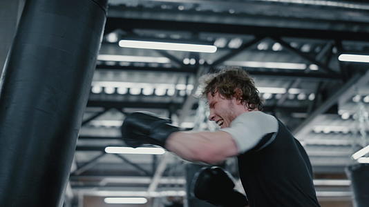 焦虑的拳击手在健身房打拳击袋视频的预览图