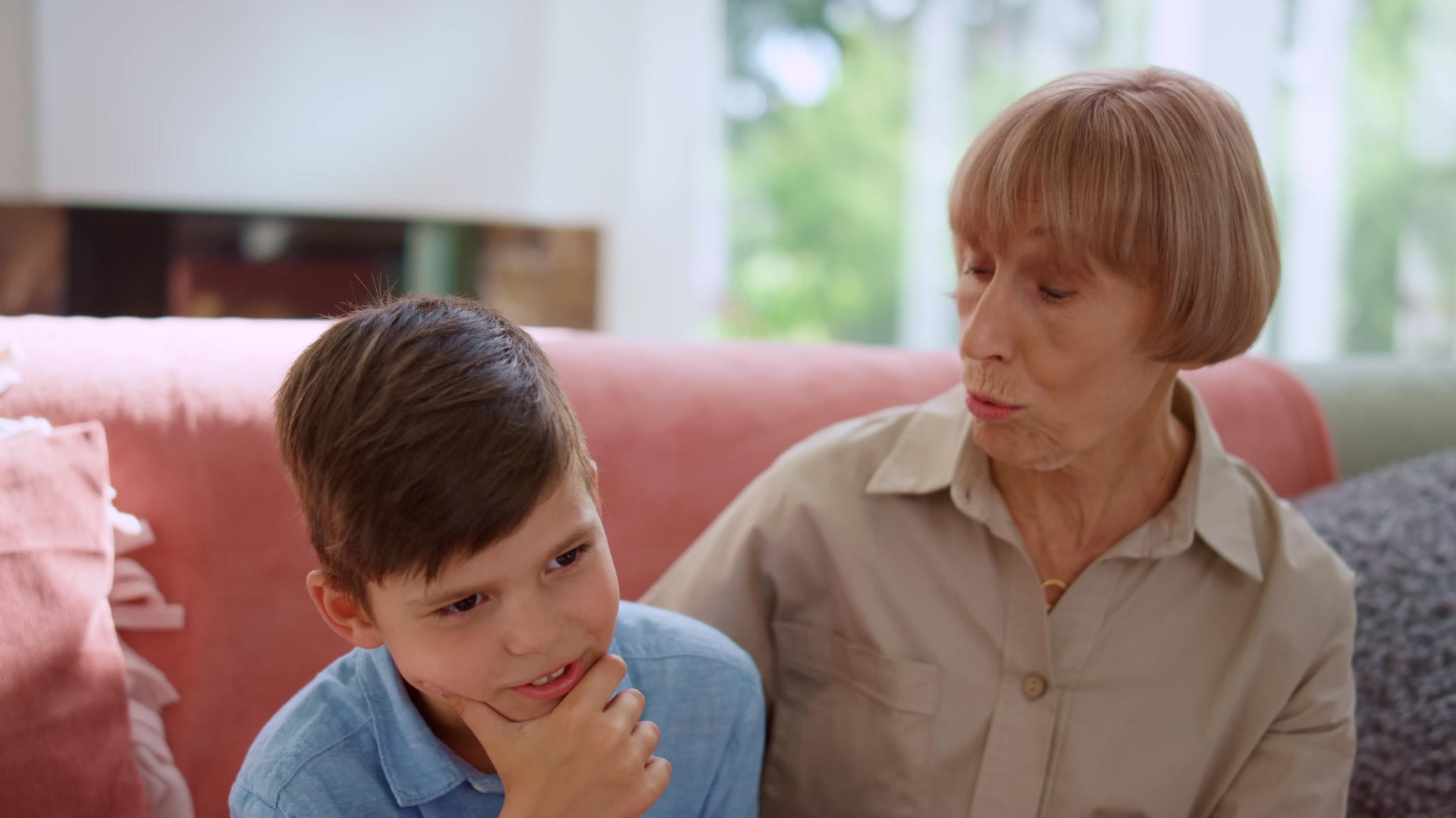 孙子手里拿着下巴和祖母坐在沙发上视频的预览图
