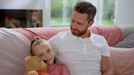 可爱的女儿和父亲坐在沙发上视频的预览图